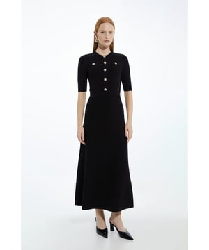Elevate your evening wardrobe in our midaxi dress, with a figure hugging bodice that flares into a long skirt, and metallic hardware. Style it with heels, loafers, or sandals for an evening look perfect for occasions that require something a little extra. Rib Knit Military Trim Midaxi Dress High Quality Ribbed Knit Fabric Metallic Button Detailing High, Round Neckline Three Quarter Length Sleeves Flattering Fit and Flare Silhouette