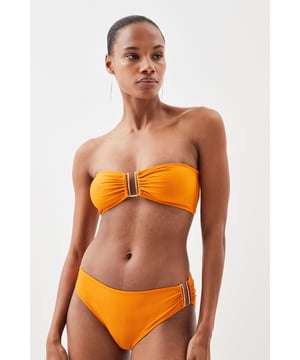These sophisticated Karen Millen bikini bottoms bring a touch of luxury to your beachwear collection. The striking gold trim adds a refined accent that catches the light beautifully as you lounge poolside or stroll along the shore. Pair with the coordinating bandeau top for a cohesive look that's perfect for your summer getaway. Style with oversized sunglasses and a flowing kaftan for elegant poolside glamour, or team with a linen shirt and sandals when heading to a beachside lunch. These bottoms offer the perfect balance of comfort and sophistication for your next sun-soaked holiday.   Distinctive gold-tone trim detail on the side Mid-rise design offering comfortable coverage and a flattering silhouette Soft, stretchy fabric Sleek, minimalist design that pairs beautifully with the matching bandeau top  Matching piece sold separately.