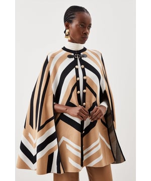 Nothing spells the changing of the seasons like a sleek cape. This covetable design is perfect for all your autumnal adventures, featuring an equestrian-style buckle fastening and cosy, knitted construction. Glossy military-inspired buttons line the front, adding to its luxe allure ? simply slip it on over your outfit for an instantly polished finish. Style: CapeDesign: PlainFabric: KnittedLength: RegularNeckline: CollarlessSleeve Length: Sleeveless Discover our blog post on the most popular coats & jackets for AW24 here.
