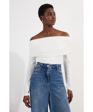 This Karen Millen Bardot bodysuit offers effortless sophistication for your everyday wardrobe. The off-shoulder design creates a flattering silhouette while the slinky jersey fabric drapes across the dcolletage. Style with high-waisted wide-leg jeans, or pair with a flowing midi skirt and ballet flats. For cooler evenings, layer with an oversized cardigan without compromising on the elegant neckline. The versatile design transitions seamlessly from daytime casual to evening drinks, simply swap to block heels and add statement earrings to transform your look.   Elegant Bardot neckline with a ruched fold-over detail Crafted from soft, drapey slinky jersey Secure bodysuit design Long sleeves