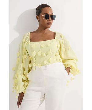 This Karen Millen woven top features all-over appliqu detailing that catches the light with every movement. The dramatic balloon sleeves create a romantic silhouette that balances perfectly with the sophisticated Bardot neckline. Style this statement piece for daytime occasions by pairing it with crisp white trousers as shown, adding oversized sunglasses for a touch of glamour. The loose fit makes it ideal for family gatherings or brunches with friends, where comfort and style are equally important. For cooler weather, layer over slim-fit trousers with flat sandals or trainers for an effortlessly stylish look.  Striking appliqu detailing Elegant Bardot neckline frames the dcolletage Statement balloon sleeves Loose-fitting silhouette