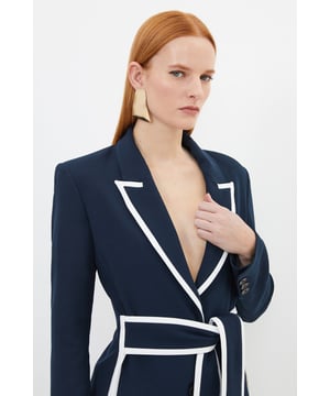 This Karen Millen belted blazer redefines smart-casual dressing with its distinctive tipped detailing and contemporary silhouette. The tailored design with its waist-cinching belt creates a feminine shape that works brilliantly for daytime engagements. Style with wide-leg trousers and statement earrings for family gatherings, or pair with your favourite straight-leg jeans and trainers for a polished weekend look. The compact stretch fabric ensures comfort without compromising on structure, making this blazer ideal for busy days when you need to look put-together. For cooler weather, layer over a fine knit top, or wear it open over a simple camisole during warmer months. This versatile piece transitions effortlessly from office to casual meetups, offering endless styling possibilities for your wardrobe.   Striking contrast tipped detailing along the lapels and belt Tailored silhouette with a flattering belted waist to define your figure Compact stretch fabric offers comfortable movement Collared neckline with notched lapels for a classic blazer aesthetic