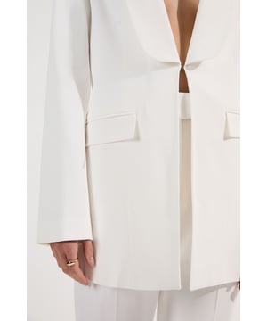 Command attention in the boardroom with this impeccably crafted Karen Millen blazer. The tailored silhouette creates a sophisticated profile that transitions effortlessly from day to evening engagements. Style with the matching trousers for a coordinated power suit that makes a bold statement, or pair with slim-fit trousers and a silk blouse for a refined workwear ensemble. The versatile design works with both heels and smart flats, whilst the addition of delicate jewellery will enhance the blazer's elegant appeal. The slight stretch in the fabric ensures comfort throughout your busy day without sacrificing the structured, professional appearance that defines this essential wardrobe investment.  Tailored single-breasted design with sophisticated shawl collar Structured shoulders and long sleeves create a powerful, confident shape Functional front pockets Single front closure maintains the blazer's sleek, minimalist aesthetic Regular fit