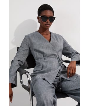 This Karen Millen Tailored Marl Tie Waist Blazer redefines smart-casual dressing with its contemporary collarless design and sophisticated wrap silhouette. The adjustable tie waist allows you to customise your fit while creating a feminine shape that works beautifully for daytime engagements. Style with the matching wide-leg trousers as seen on our model for an impeccably coordinated ensemble, perfect for family gatherings or lunch with friends. For a more relaxed approach, pair with slim-fit jeans and leather trainers, adding statement earrings for a touch of personality. The structured shoulders and clean lines make this blazer an excellent layering piece for transitional weather, simply add a fine-knit top underneath for cooler days. Complete your look with a structured clutch bag for an effortlessly polished daywear outfit that conveys confidence and style.  Collarless wrap design with elegant tie waist detail for a flattering silhouette Tailored marl fabric with subtle texture adds sophisticated dimension Functional side pockets provide practicality without compromising style Regular fit with structured shoulders creates a refined daywear profile Versatile blazer that pairs effortlessly with matching trousers for a coordinated look  Matching piece available, sold separately.