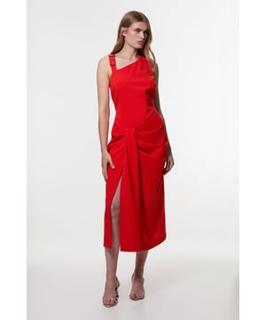 This Karen Millen tailored dress redefines workwear with its architectural asymmetric neckline and contemporary strappy detail. The thoughtfully placed draping at the waist creates a figure-enhancing silhouette, whilst the midi length with side split strikes the perfect balance between professional and stylish. Style with pointed court shoes and a structured blazer for important meetings, or dress it up with statement earrings and sleek heels for after-work functions. The versatile design transitions seamlessly from day to evening, making it an indispensable addition to your professional wardrobe. The clean lines and modern detailing reflect a sophisticated aesthetic that commands attention in the boardroom without compromising on comfort or style.  Striking asymmetric neckline with strappy detail featuring metal eyelets Sophisticated midi length with elegant side split Flattering draped fabric detail at the waist Sleek, tailored silhouette with a structured fit Square back design