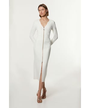 Elevate your cold weather wardrobe in our long sleeve dress, with a fitted silhouette, metallic zip detailing, and a unique V neckline. Style it with heeled boots or chunky loafers for an elevated day to night look. Zip Up Full Needle Knitted Dress High Quality Soft Knit Fabric Flattering Figure Hugging Silhouette Rounded V Neckline Zip Front Fastening Thigh High Leg Split