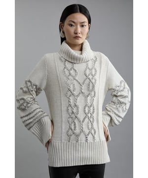 Sumptuous texture meets opulent crystals in this cable knit jumper. Embellished with intricate diamante details, this jumper takes knitwear to an elevated level. A chunky turtle neckline and cable knit texture keeps a classic element, allowing this piece to be styled for both everyday and eveningwear.Cable knit jumperChunky turtle neckLong sleevesEmbellished