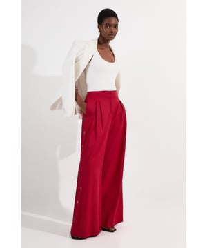 Make a statement with these Karen Millen wide leg trousers, featuring an eye-catching button-side detail that transforms a classic silhouette into something truly special. The high-waisted design with front pleating creates a flattering shape that elongates your legs, while the generous wide cut offers both comfort and drama. Add a tailored blazer and minimal jewellery for lunch with friends, or dress down with a casual knit and trainers for weekend shopping trips. These versatile trousers transition effortlessly from day to evening, simply swap your flats for heeled mules when heading out for dinner. The soft fabric blend moves with every step, ensuring you feel as confident as you look.   Distinctive button-side detail High-waisted design with pleated front Practical side pockets Soft cotton blend fabric offers comfort with gentle stretch