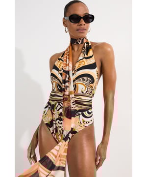 Make a statement by the water with this Karen Millen scarf print swimsuit. The eye-catching design combines a daring plunge neckline with the versatility of a detachable scarf that can be styled multiple ways - wrapped around your neck, tied as a headband, or even as a wrist accessory. The halterneck silhouette provides excellent support while the high-cut leg creates a lengthening effect that flatters your natural shape. Perfect for making an impression at exclusive beach clubs, pair with oversized sunglasses and statement earrings as styled for a sophisticated poolside ensemble. This swimsuit transitions effortlessly from daytime swimming to evening beachfront dining. Simply add a flowing maxi skirt and metallic sandals for an elegant resort look that captures attention for all the right reasons.   Striking scarf print design with bold swirling pattern throughout Plunging neckline creates a dramatic, sophisticated silhouette Halterneck style with elegant open back for a flattering fit Detachable scarf feature offers versatile styling options High-cut leg design elongates the figure for a confident poolside look