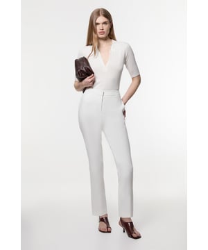 These Karen Millen tailored trousers combine professional polish with modern comfort. The slim leg design creates a refined silhouette that transitions seamlessly from boardroom to evening engagements. Style with a coordinating blazer and pointed flats for a sophisticated workwear ensemble, as shown by our model, or pair with a crisp white shirt and block heels for client meetings. The stretch-enhanced fabric allows for comfortable movement whilst maintaining structure, ideal for long days at the office. For after-work occasions, simply add statement jewellery and swap flats for elegant heels. These versatile trousers form the foundation of a capsule workwear wardrobe, offering endless styling possibilities whilst maintaining a distinctly professional appearance. Their timeless design ensures they'll remain a wardrobe staple for seasons to come.  Tailored slim leg design with clean, streamlined silhouette Stretch fabric blend for exceptional comfort and movement Sleek waistband with subtle front closure Versatile 60cm length perfect for pairing with flats or heels Sophisticated straight-leg cut that maintains its shape throughout the day  Matching piece sold separately.