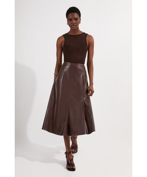 This Karen Millen faux leather midi skirt combines timeless elegance with contemporary edge. The full silhouette creates a dramatic swish with every step, while the high waistline accentuates your natural curves. Style with a fitted top for a balanced silhouette that highlights the skirt's voluminous design. For casual gatherings, pair it with a simple knit jumper and ankle boots, or dress it up with a crisp blouse and block heels for dinner dates. The versatile midi length works with both flats and heels, making this piece adaptable for family gatherings or weekend brunches. Add a cropped jacket and statement jewellery to transform this skirt into an ensemble that transitions effortlessly from day to evening wear.  Faux leather midi skirt with a full, flowing silhouette High-waisted design Elegant pleating detail Midi length Smooth finish with a subtle sheen