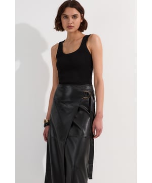 This Karen Millen wrap midi skirt showcases sophisticated urban style with its distinctive tie detail and statement buckle. The asymmetric wrap design creates a flattering silhouette. For family gatherings or brunches with friends, team with a fine knit jumper and trainers for an effortlessly stylish look. The versatile midi length makes this piece ideal for transitional weather, while the faux leather texture adds a contemporary touch to your wardrobe.   Striking wrap design with elegant tie detail Distinctive buckle hardware Midi length Faux leather