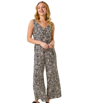 Dusk Abstract Print Jumpsuit from Roman. Effortlessly chic and perfect for the warmer months, this abstract jumpsuit is a must-have for your Spring/Summer wardrobe. Featuring a flattering v-neckline and stylish sleeveless design, this jumpsuit is the epitome of easy elegance. Pair it with sandals and a denim jacket for a laid-back yet sophisticated look that will take you from day to night with ease.