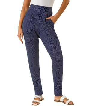 Spot Print Harem Trouser from Roman. Add a touch of fun to your wardrobe with these stylish harem spot print trousers. These full length trousers are fully printed for a statement look and include two practical pockets. Pair them with a simple t-shirt and a cosy cardigan for a chic and effortless style that's perfect for the Spring/Summer season!