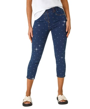 Embellished Cropped Stretch Jeggings from Roman. Get ready to sparkle in these cropped jeggings this Spring Summer! Featuring functional belt loops and a flattering shape, these denim jeggings are adorned with beautiful embellished details. Cut from a soft, stretch cotton fabric, they finish at a stylish cropped length. Pair with a white blouse and wedge sandals for a trendy outfit that effortlessly transitions from day to night.