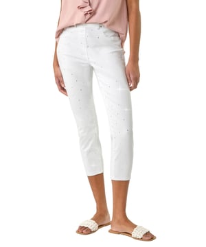 Embellished Cropped Stretch Jeggings from Roman. Get ready to sparkle in these cropped jeggings this Spring Summer! Featuring functional belt loops and a flattering shape, these denim jeggings are adorned with beautiful embellished details. Cut from a soft, stretch cotton fabric, they finish at a stylish cropped length. Pair with a white blouse and wedge sandals for a trendy outfit that effortlessly transitions from day to night.