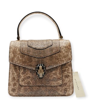 The Serpenti Forever small top handle bag showcases exquisite craftsmanship with its hand-crafted and meticulously painted body, crafted from luxurious silver pearled karung skin. This elegant creation seamlessly combines refined materials with practical versatility, featuring a distinctive snake body-shaped chain paired with a leather strap. The iconic snakehead magnetic closure, inspired by Serpenti jewelry from the 1960s, adds a captivating touch with its intricate scale design. The bag is thoughtfully designed with three compartments, a rear patch pocket, an interior open pocket, a dedicated mirror pocket with a customizable mirror, an inner metal tag displaying the Bvlgari logo, and the signature Bvlgari metal logo on the back.
Inclusion: Rain shield, dustbag, card of authentication, strap, small mirror 
Remarks: Overall no damages 
NFT option available. Discover more.
Assured Product Authenticity: This product is supplied by a renowned and trusted partner.
With this purchase, you are preserving iconic craftsmanship, celebrating heritage, and embracing the beauty of conscious shopping.Measurments:  width: 228 mm length: 482 mm height: 425 mm strap length: 1050 mm handle drop: 584.2 mm