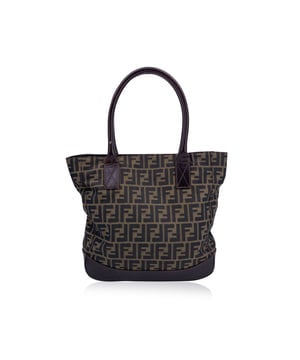 VINTAGE, RRP AS NEW
Step into the timeless elegance of Italian fashion with this stunning Fendi Zucca tote bag in the classic tobacco colorway. A true emblem of the house's heritage, the bag is crafted in the iconic FF monogram Zucca canvas-a pattern designed by Karl Lagerfeld himself in the 1960s and still turning heads decades later.  Trimmed in rich brown leather with matching rolled handles, it balances rugged structure and soft sophistication. Upper magnetic button closure. Five protective feet guard the base like a well-kept secret.  Inside, you'll find Fendi's signature logo fabric lining, a secure zip pocket, and the unmistakable mark of ity: a tag that reads "Fendi s.a.s. Roma - Made in Italy." This tote isn't just an accessory-it's a piece of fashion history. Condition Rating: A - EXCELLENTCondition Details: Gently used. Some light scratches on leather trim and on bottom corners. Please check the photos carefully and ask if you need to know more details or if you have any doubts.Measurements (cm):Depth: 10.2Height: 30.5Length: 39.4Other Details: Dustbag? NoKeys? NoBox? No Measurments:  width: 102 mm length: 394 mm height: 305 mm