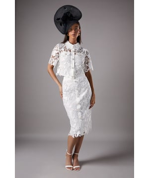 Exquisite lace overlay with intricate floral pattern
        Elegant pearl button detailing down the front
        Figure-hugging pencil silhouette
        Midi length for a sophisticated look
        Scalloped hem adds a delicate finishing touch
    
    Make a striking impression at your next special occasion with this stunning lace pencil skirt. The intricate floral lace overlay creates a luxurious texture, while the row of pearl buttons down the front adds a touch of vintage-inspired glamour. The figure-flattering pencil silhouette and midi length offer a timeless elegance perfect for weddings, race days, or formal events. Style this versatile piece with a silk blouse and strappy heels for a chic ensemble, or pair it with a matching lace top for a coordinated look that's sure to turn heads. The scalloped hem provides a beautiful finishing detail, ensuring you'll feel confident and sophisticated from day to night. This Coast skirt is a wardrobe essential for the fashion-forward woman who appreciates quality craftsmanship and eye-catching design.