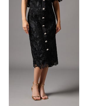 Exquisite lace overlay with intricate floral pattern
        Elegant pearl button detailing down the front
        Figure-hugging pencil silhouette
        Midi length for a sophisticated look
        Scalloped hem adds a delicate finishing touch
    
    Make a striking impression at your next special occasion with this stunning lace pencil skirt. The intricate floral lace overlay creates a luxurious texture, while the row of pearl buttons down the front adds a touch of vintage-inspired glamour. The figure-flattering pencil silhouette and midi length offer a timeless elegance perfect for weddings, race days, or formal events. Style this versatile piece with a silk blouse and strappy heels for a chic ensemble, or pair it with a matching lace top for a coordinated look that's sure to turn heads. The scalloped hem provides a beautiful finishing detail, ensuring you'll feel confident and sophisticated from day to night. This Coast skirt is a wardrobe essential for the fashion-forward woman who appreciates quality craftsmanship and eye-catching design.