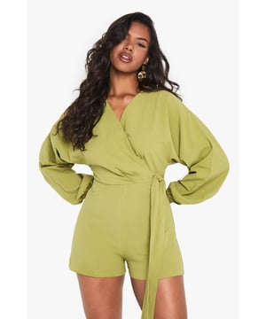 Wrap-over design with tie detail for adjustable fit
        Flattering V-neckline
        Voluminous balloon sleeves for dramatic flair
        Linen-look fabric for a breezy, textured appearance
        Versatile playsuit suitable for various casual occasions
    
    Embrace effortless chic with this wrap-over tie detail playsuit from Boohoo. The linen-look fabric offers a lightweight feel, perfect for warm-weather outings. Its striking balloon sleeves add a touch of drama to the silhouette, while the V-neckline flatters your dcolletage. Style this playsuit with strappy sandals and a woven bag for a laid-back brunch with friends. For family gatherings, pair it with white trainers and delicate gold jewellery. The adjustable tie allows you to customise the fit, making it a versatile piece for your wardrobe. Whether you're heading to a casual garden party or a day out shopping, this playsuit offers both comfort and style. Its relaxed yet put-together look makes it an ideal choice for those who want to stay on-trend without compromising on ease.