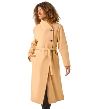 Asymmetric Double Breasted Tie Waist Coat from Roman. Wrap up in style this Autumn Winter with our fashionable, asymmetric double breasted coat. The unique asymmetric front and contrasting button fastenings add a modern touch to this classic coat silhouette. Featuring a tie waist belt detail for a flattering cinched-in look, this coat is crafted from a comfy woven fabric and fully lined for extra warmth. Finished with angled side pockets and long raglan sleeves, this coat is a must-have for your cold weather wardrobe. Pair with your favourite knit and ankle boots for a complete look!