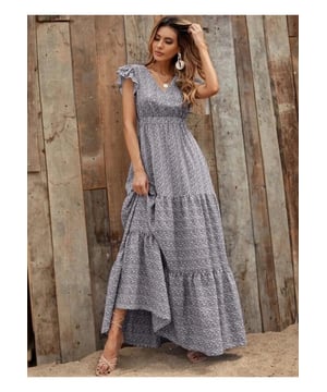 Diseño con volantes  
Construcción en capas  
Sin elasticidad  
100% poliéster  
Lavar a máquina en frío, secar a baja temperatura  
Importado  
Material: El vestido parece estar hecho de una tela ligera, posiblemente de algodón o rayón. El material parece suave y fluido, adecuado para climas cálidos.