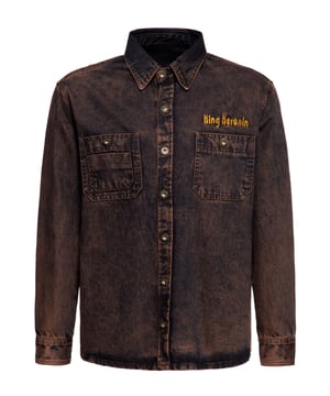 Auf dem Highway des Lebens zieht das neueste Workwear-Hemd von King Kerosin alle Blicke auf sich. Hergestellt aus robustem Denim, überzeugt es durch eine außergewöhnliche Tint Wash in Rost-Optik. Die Stickerei begleitet von den Worten "Split the Road - Route to Liberty.", symbolisiert nicht nur endlose Straßen und atemberaubende Sonnenuntergänge, sondern verkörpert das pulsierende Herz eines Bikers und sein brennendes Fernweh. Das Langarmhemd in Regular Fit garantiert durch den Denimstoff nicht nur den rustikalen Charme, sondern auch einen stilbewussten Auftritt. Die großzügigen Brusttaschen mit Knöpfen bieten ausreichend Platz für all deine Essentials. Mit den 1-Knopf-Manschetten lassen sich die Ärmel mühelos hochkrempeln und dank der Lasche zuverlässig fixieren, was es zum perfekten Begleiter für Arbeit und Freizeit macht. Die metallenen Knöpfe setzen rustikale Akzente und verstärken den einzigartigen Vintage-Charakter dieses Denim-Hemdes. Kombiniere es lässig mit einem einfachen T-Shirt und offener Knopfleiste oder schichtweise über einem Rollkragenpullover für eine warme und stilvolle Note.  KING KEROSIN: Vintage, Retro, Biker, Motorräder, Hot Rod, Tattoos, Rockabilly und Rock'n'Roll. Das alles beschreibt unsere Designs perfekt, die an den wilden Lifestyle der 50er angelehnt sind.DESIGN: Hergestellt aus robustem Denim, überzeugt dieses Workwear-Hemd durch eine außergewöhnliche Tint Wash in Rost-Optik. Der rustikale Charme, die hochwertige Stickereien, die 1-Knopf-Manschetten an den Ärmeln, die mühelos dank einer Lasche hochgekrempelt werden können, machen dieses Langarmhemd einzigartig. Die metallene Knöpfe und die großzügigen Brusttaschen mit Knöpfen verstärken den einzigartigen Vintage-Charakter dieses Denim-Hemdes.PASSFORM: Bequem geschnitten dank Regular Fit.MATERIAL: Aus langlebiger, strapazierfähiger Baumwolle hergestellt.
