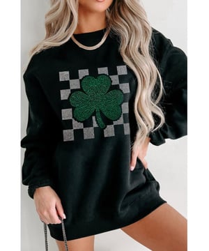 Patrón de cuadros con strass y motivo de trébol de la suerte  
Diseño de cuello redondo  
Fabricado en un 50% de poliéster y un 50% de algodón  
Material ligeramente elástico  
Tela opaca  
Lavable a máquina en frío, secar a baja temperatura  
Importado  
Disponible en tallas S a 2XL