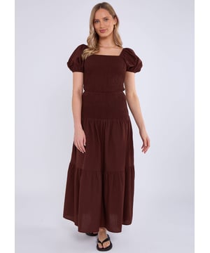 Eleva tu estilo con nuestro top de algodón con mangas abullonadas y fruncido en color chocolate. Confeccionado en lujoso algodón, el diseño fruncido y las mangas abullonadas añaden un toque de estilo a cualquier armario. Mantente cómoda y a la moda durante todo el día.