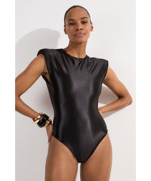 Make a statement poolside with this Wet Look Power Shoulder Cut Out Swimsuit. The architectural power shoulders create a bold, fashion-forward silhouette that commands attention, whilst the strategic cut-out detail adds intrigue to this one-piece design. Perfect for lounging by the pool at exclusive resorts or enjoying sunny beach days, this swimsuit transitions effortlessly from daytime swimming to sunset cocktails when paired with a flowing maxi skirt and statement jewellery. The sleek wet look fabric hugs your curves in all the right places, offering both style and comfort for your summer getaways.   Wet look finish catches the light. Bold power shoulder design Sleek cut-out detail Crew neckline offers coverage High-cut design elongates your figure