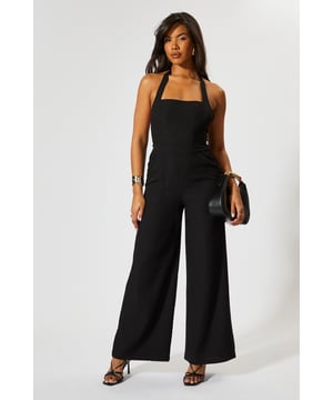 Chic halterneck design with elegant square neckline
        Straight leg silhouette for a flattering, contemporary look
        Backless feature adds a striking touch of glamour
        Wide-leg trousers create a flowing, sophisticated shape
        Linen-look fabric offers a textured finish with comfortable wear
    
    This MissPap jumpsuit combines effortless style with head-turning appeal. The halterneck design frames the dcolletage beautifully, whilst the backless detail creates a show-stopping moment when you turn around. Perfect for casual gatherings, style with strappy heels and statement earrings as seen on our model for evening drinks, or dress down with flat sandals and a woven tote for daytime events. The straight fit and wide-leg trousers create a relaxed yet polished silhouette that moves gracefully with every step. Layer with a cropped denim jacket for cooler evenings or add a waist belt to define your figure further. This versatile piece transitions seamlessly from family gatherings to sunset cocktails, making it an essential addition to your warm-weather wardrobe.