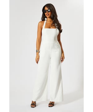 Chic halterneck design with elegant square neckline
        Straight leg silhouette for a flattering, contemporary look
        Backless feature adds a striking touch of glamour
        Wide-leg trousers create a flowing, sophisticated shape
        Linen-look fabric offers a textured finish with comfortable wear
    
    This MissPap jumpsuit combines effortless style with head-turning appeal. The halterneck design frames the dcolletage beautifully, whilst the backless detail creates a show-stopping moment when you turn around. Perfect for casual gatherings, style with strappy heels and statement earrings as seen on our model for evening drinks, or dress down with flat sandals and a woven tote for daytime events. The straight fit and wide-leg trousers create a relaxed yet polished silhouette that moves gracefully with every step. Layer with a cropped denim jacket for cooler evenings or add a waist belt to define your figure further. This versatile piece transitions seamlessly from family gatherings to sunset cocktails, making it an essential addition to your warm-weather wardrobe.
