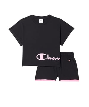 Deze tweedelige set bestaat uit een T-shirt met korte mouwen en een korte broek. De broek heeft een elastische tailleband met trekkoord. De broekspijpen zijn in een contrasterende kleur afgebiesd. Het T-shirt heeft korte, overlappende mouwen met omslag en een beleg aan de halsopening. De taille is kort en omgezoomd. Bijzondere details worden aan de set toegevoegd door de opdruk van de tekst op het T-shirt en de kleine logo-opdruk op de broek.