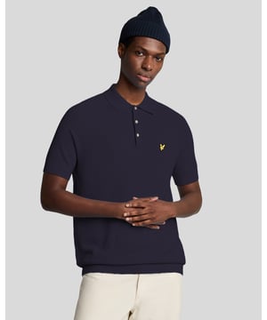 Maak kennis met het gebreide poloshirt van linnenmix, een onderscheidend item binnen onze premium herenmodecollectie. Gemaakt van een verfijnde mix van 60% katoen, 30% viscose en 10% linnen, heeft deze gebreide polo een klassieke sluiting met 3 knopen en wordt geaccentueerd door een gouden geborduurde adelaar linksboven op de borst. Het verfijnde ontwerp en de luxueuze materialen maken het een essentiële aanvulling op de garderobe van elke veeleisende heer. - Samenstelling: 60% katoen, 30% viscose, 10% linnen - Pasvorm: Regular - Logo: Gouden geborduurde adelaar - Locatie kledingstuk: Linksboven op de borst - Veelzijdige styling, geschikt voor zowel casual als smart-casual gelegenheden. Omarm het seizoen met deze elegante gebreide polo, die moeiteloos comfort en verfijning combineert.
