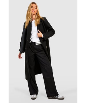 Double-breasted design for a classic, sophisticated look
        Longline silhouette offers extended coverage and warmth
        Notched lapels add a touch of timeless elegance
        Long sleeves with buttoned cuffs for a polished finish
        Side pockets provide practicality and a place to warm your hands
    
    Make a statement in this striking double-breasted longline coat from Boohoo. Perfect for the fashion-forward woman who wants to command attention, this coat combines classic tailoring with contemporary flair. The wool-look fabric gives the impression of luxury without the hefty price tag, making it an ideal choice for the savvy shopper. Style it over a crisp white shirt and wide-leg trousers for a chic office ensemble, or throw it on over a little black dress for an evening out. The versatile nature of this coat means it can easily transition from day to night, making it a must-have addition to your wardrobe. Whether you're heading to a important meeting or a sophisticated soire, this coat will ensure you look put-together and stylish. Pair with sleek trainers for a modern twist on smart-casual, or dress it up with heels for a more formal occasion.
