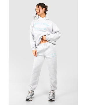 Cosy tracksuit with New York embroidery
        Relaxed fit hoodie with ribbed cuffs and hem
        Matching joggers with tapered leg
        Soft cotton-feel fabric for ultimate comfort
        Versatile two-piece set for effortless styling
    
    Embrace laid-back chic with this petite tracksuit, perfect for those who want to make a statement whilst staying comfortable. The New York embroidery adds a touch of urban flair, making it ideal for city dwellers and travellers alike. Style this set with chunky trainers for a casual day out, or dress it up with statement jewellery and heeled boots for an evening with friends. The versatility of this tracksuit means it can take you from lounging at home to running errands in town with ease. For a sporty look, pair with a baseball cap and crossbody bag. This tracksuit is a must-have for your casual wardrobe, offering both style and comfort for various informal occasions.