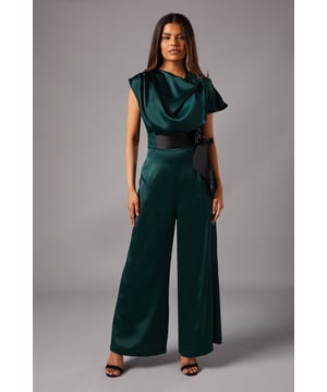 Elegant cowl neckline that drapes beautifully across the dcolletage
        Luxurious satin fabric with a lustrous sheen that catches the light
        Flattering wide leg silhouette for effortless movement
        Striking contrast tie side detail that cinches the waist
        Cap sleeve design offering sophisticated coverage
    
    Make a statement at your next special occasion with this exquisite Petite Tie Side Satin Drape Wide Leg Jumpsuit from Coast. The flowing wide leg design creates a dramatic silhouette whilst the cowl neckline adds a touch of timeless sophistication. The contrasting tie detail accentuates the waist beautifully, creating a flattering hourglass shape. Style with strappy heeled sandals, as shown on our model, and add a clutch bag for a refined evening ensemble. Perfect for weddings, race days or formal gatherings where you wish to project confidence and grace. The petite fit ensures the proportions work harmoniously for smaller frames, eliminating the need for alterations. This jumpsuit offers the perfect balance of comfort and elegance for those memorable moments.