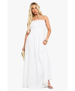 Elegant bandeau neckline with delicate ruched detailing across the bodice
        Lightweight cotton poplin fabric offers breathable comfort for all-day wear
        Floor-sweeping maxi length creates a graceful silhouette
        Elasticated shirred upper section ensures a comfortable, secure fit
        Flowing skirt design provides effortless movement and versatility
    
    This stunning cotton maxi dress showcases beautiful ruched detailing that creates a flattering silhouette whilst maintaining day-long comfort. The strapless bandeau design presents the perfect canvas for showcasing your favourite jewellery, as demonstrated by the model's choice of layered necklaces. Style with flat sandals and a woven clutch for casual garden parties or family gatherings. For a more refined daytime look, add a cropped denim jacket and delicate bangles. The dress's relaxed fit makes it ideal for warm-weather holidays - simply throw on with oversized sunglasses and a wide-brimmed hat for instant beachside sophistication. The versatile design transitions seamlessly from day to evening, making it a must-have addition to your summer wardrobe.
