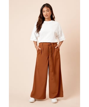 Wide leg design with elegant pleated detailing for added dimension and movement
        Self-fabric belt with loop fastening creates a flattering, cinched waist silhouette
        Practical side pockets perfect for everyday essentials
        Smooth woven fabric with slight stretch for all-day comfort
        High-rise waistband with belt loops for a secure and comfortable fit
    
    These sophisticated wide leg trousers combine comfort with contemporary style for the modern woman. The pleated front adds texture whilst the self-tie belt creates a beautifully defined waistline that complements the flowing wide leg cut. Style with a fitted tank top as shown for casual brunches, or pair with a tucked-in blouse and ballet flats for family gatherings. The versatile design transitions effortlessly from day to evening - simply swap your trainers for a block heel and add a cropped jacket for dinner with friends. These trousers are particularly flattering for petite frames, as the high waist and vertical pleats create the illusion of height. The lightweight fabric drapes beautifully with each step, making these an essential addition to your daywear collection that will see you through multiple seasons with ease.