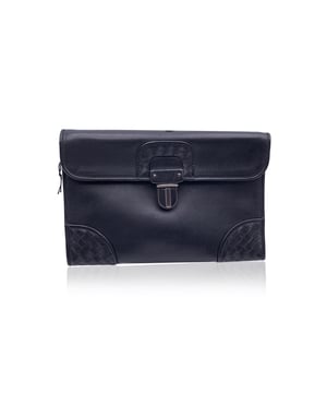 VINTAGE, RRP AS NEW
Understated elegance meets artisanal mastery in this vintage Bottega Veneta black leather wrist bag. Crafted in supple leather, this sleek piece is elevated by the brand's signature Intrecciato weave, subtly framing the corners and flap closure - a quiet nod to Bottega's heritage of handwoven luxury.  The structured flap front secures with a classic lock closure, opening to reveal a minimalist black fabric-lined interior, just enough for your essentials. A leather wrist strap adds both function and flair, making it the perfect companion for evenings out or a refined daytime statement.  Inside, the engraved 'Bottega Veneta - Made in Italy' inscription confirms what the craftsmanship already suggests: this is quiet luxury at its finest, designed to be worn, admired, and passed on. Condition Rating: B - VERY GOOD CONDITIONCondition Details: Some light scratches on leather due to normal use. Please check the photos carefully and ask if you need to know more details or if you have any doubts.Measurements (cm):Depth: 5.1Height: 16.5Length: 24.1Other Details: Dustbag? YesKeys? NoBox? No Measurments:  width: 51 mm length: 241 mm height: 165 mm