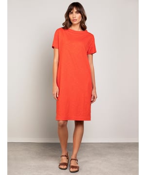This knee-length dress offers a relaxed, straight fit with a folded boat collar and grown-on sleeves. The slub jersey fabric adds subtle texture, while practical side seam pockets provide versatility for everyday wear.