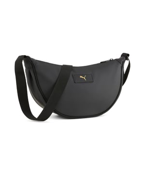 PRODUCT STORY: Elevate your essentials with this PUMA bag featuring a sleek PU body, golden embossed logo, and adjustable shoulder strap. Perfect for daily adventures, it offers a main zip compartment and an inside zip pocket for your must-have items. FEATURES & BENEFITS: Made with at least 30% recycled materials. DETAILS: Zip opening into main compartment; Inside zip pocket; Adjustable webbing shoulder strap with plastic hardware; Golden PUMA Cat Logo embossed on PU badge on front; PU body fabric; Dimensions: W33cm / D10cm / H17cm; Volume: 3L; PUMA branding details.