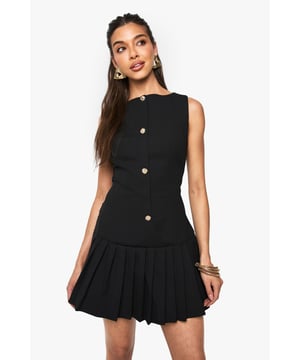 Sleeveless mini dress with elegant slash neckline for a sophisticated silhouette
        Decorative button detail running down the front adds a chic, structured element
        Pleated skirt creates playful movement and a flattering flare
        Fitted waist design accentuates your natural shape
        Versatile crepe fabric offers comfortable stretch whilst maintaining structure
    
    This striking mini dress from Boohoo combines classic tailoring with contemporary flair. The fitted bodice with its distinctive button detailing creates a polished look, while the pleated skirt adds a touch of playfulness perfect for evening adventures. Style with strappy heels and statement earrings as shown for a night at the club, or dress down with chunky trainers and an oversized denim jacket for casual drinks with friends. The versatile design transitions effortlessly from day to night - pair with a tailored blazer for impromptu after-work gatherings or showcase on its own with a mini handbag for those spontaneous nights out. The structured yet comfortable fit makes this dress a reliable go-to when you want to make an impression whilst feeling confident on the dance floor.