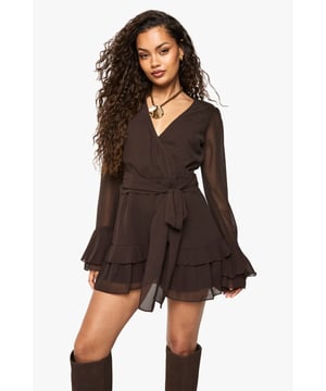 Elegant wrap-front design with flattering V-neckline
        Flowing chiffon fabric with sheer long sleeves
        Feminine double-layered ruffle hem detail
        Self-tie waist belt to create a defined silhouette
        Versatile playsuit style perfect for evening occasions
    
    Make a striking entrance in this chiffon wrap playsuit from Boohoo. The elegant wrap-front design creates a flattering silhouette, whilst the double-layered ruffle hem adds a playful touch to this sophisticated piece. Style with knee-high boots as shown for a fashion-forward look that's perfect for a night out with the girls. The sheer sleeves offer just the right amount of coverage whilst maintaining that party-ready appeal. For drinks at a trendy bar, accessorise with statement jewellery and a small clutch bag. This versatile playsuit transitions effortlessly from casual drinks to club nights, making it an essential addition to your going-out wardrobe. The tie-waist detail allows you to customise the fit to your preference, ensuring comfort throughout your evening.