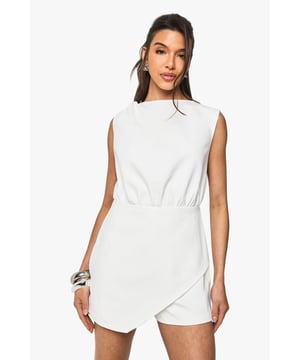 Sleek wrap-style playsuit with elegant asymmetric hem detail
        Sophisticated crew neckline and sleeveless design for a modern silhouette
        Elasticated waistband creates a flattering, defined shape
        Lightweight woven fabric offers comfortable movement for all-day wear
        Subtle back detailing with decorative hardware adds an unexpected twist
    
    This versatile wrap playsuit from Boohoo combines effortless style with practical comfort. The clean lines and minimalist design make it perfect for casual daytime events whilst being easily dressed up for evening socials. Style with metallic accessories as shown for added impact, or pair with your favourite trainers and an oversized denim jacket for a relaxed weekend look. The asymmetric wrap detail creates visual interest whilst the sleeveless cut makes it ideal for warmer days or layering. Perfect for family gatherings, brunches with friends, or casual garden parties - this playsuit offers endless styling possibilities. Add a tailored blazer and strappy heels to transform it into an outfit suitable for more sophisticated occasions.