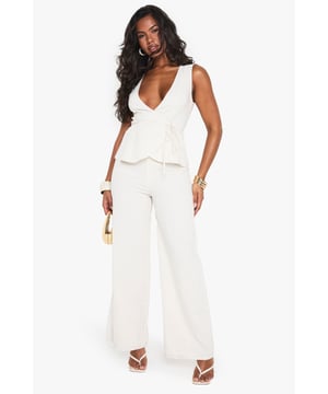 Striking linen-look jumpsuit with a daring plunge neckline for a bold statement
        Flattering peplum detail at the waist creates a feminine silhouette
        Wide-leg trousers offer comfortable movement and on-trend styling
        Sleeveless design perfect for showcasing jewellery and summer-ready arms
        Versatile piece that transitions effortlessly from day to evening occasions
    
    Make an entrance in this showstopping linen-look jumpsuit from Boohoo. The dramatic plunge neckline commands attention whilst the peplum waist detail adds a touch of feminine flair to your silhouette. The flowing wide-leg cut creates a statuesque effect that's both comfortable and fashion-forward. Style with strappy heels and stacked bangles as seen on our model for a night out with the girls, or dress down with flat sandals for daytime drinks. This jumpsuit works brilliantly for summer soires, cocktail parties, or any occasion where you want to stand out from the crowd. Layer with a tailored blazer when the temperature drops for a look that maintains its sophistication whilst adding practicality.