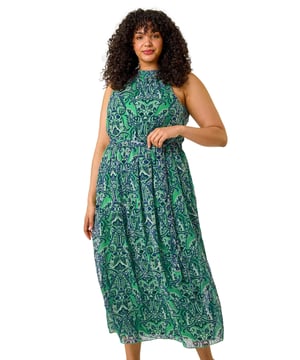 Curve Abstract Print Halter Maxi Dress from Roman. Stand out this Season with the stunning abstract print halter maxi dress. Featuring a flattering A-line silhouette and pleat detailing, this dress is perfect for any special occasion. The halter neckline adds an elegant touch, while the abstract print adds a fun and vibrant element. Pair with heels and a chic blazer for a sophisticated and eye-catching look that will turn heads wherever you go!