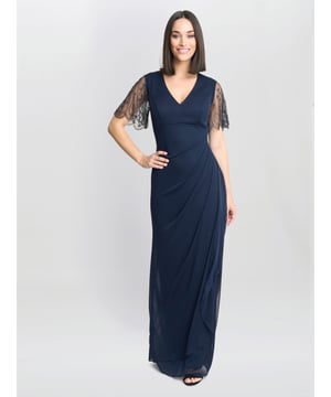 This timeless dress is crafted in a light stretch mesh and fully lined. They true blue navy colour, this dress has a wrap effect skirt and an under bust seam. The bodice is a simple V neck with wide shoulders and a delicate unlined mesh, scalloped edge sleeve, adorned with delicate beads. This dress has tucks on the back for a flattering look. It features a back zip and measures cm.