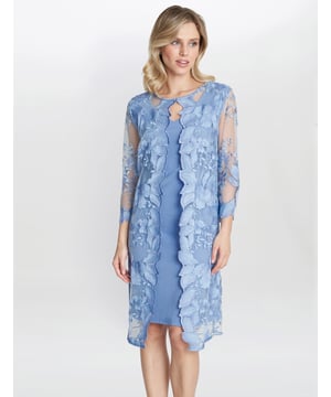 Gina Bacconi presents its stunning jersey and lace dress. This perfect occasionwear piece is comprised of a classic shift dress overlaid with a detailed floral lace and strewn with light-catching sequins. The lace features a scallop lace which adorns the front of the dress and the sleeve edge. The dress is fully lined and fastens using a concealed back zip.

Perfect for a special occasion!